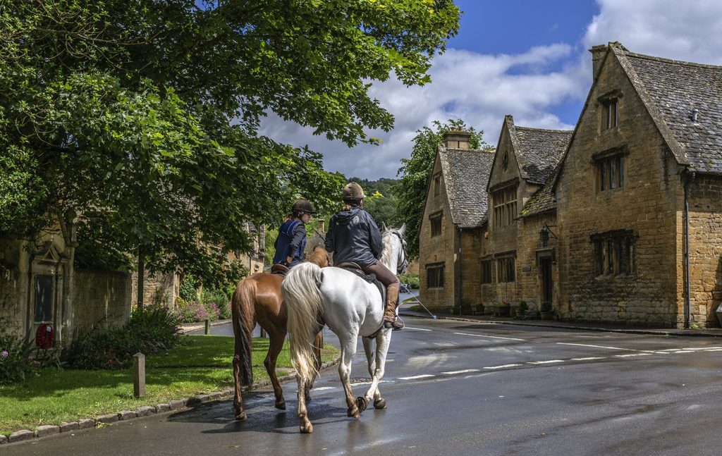 Horses and riders hacking on country road